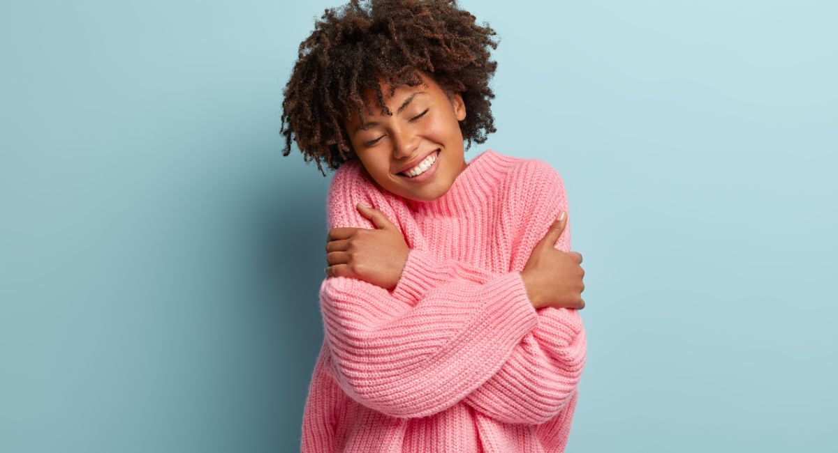 woman hugging herself, self compassion quotes