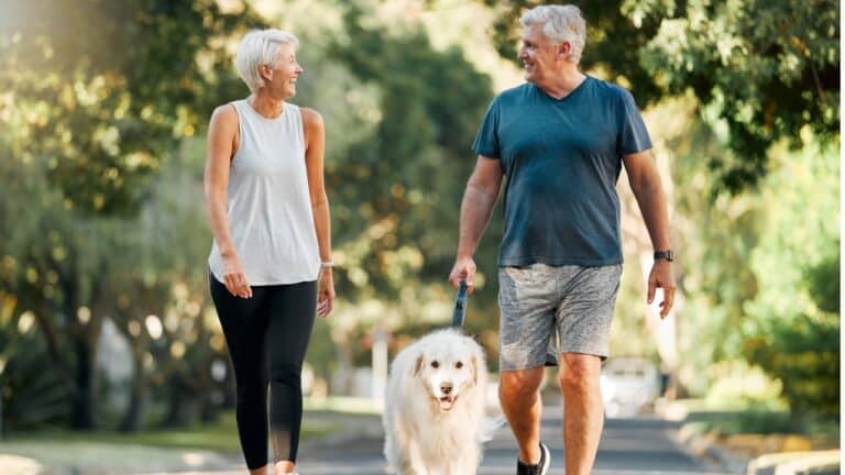 happy couple walking dog