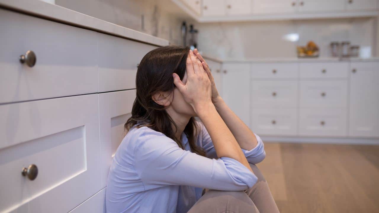 how to stop worrying, woman on the floor with her head in her hands worrying