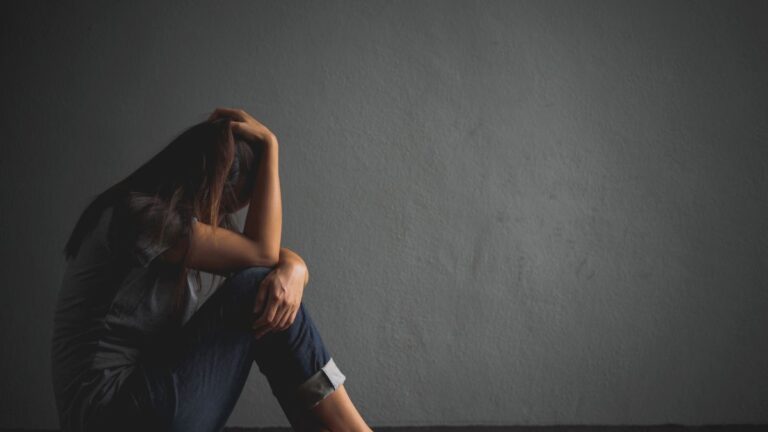 why do women stay in abusive relationships, sad woman on floor